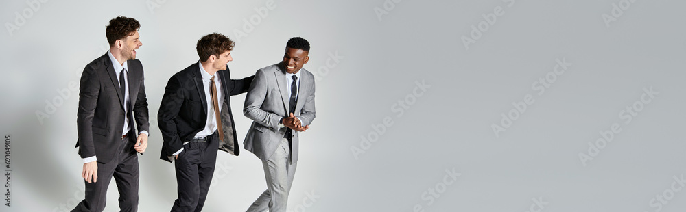 handsome jolly diverse friends in business elegant attires smiling joyfully on gray backdrop, banner handsome jolly diverse friends in business elegant attires smiling joyfully on gray backdrop, banner