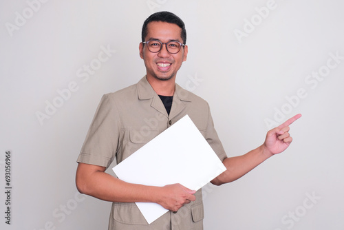 Indonesia government worker smiling and pointing to the left side while holding a document photo