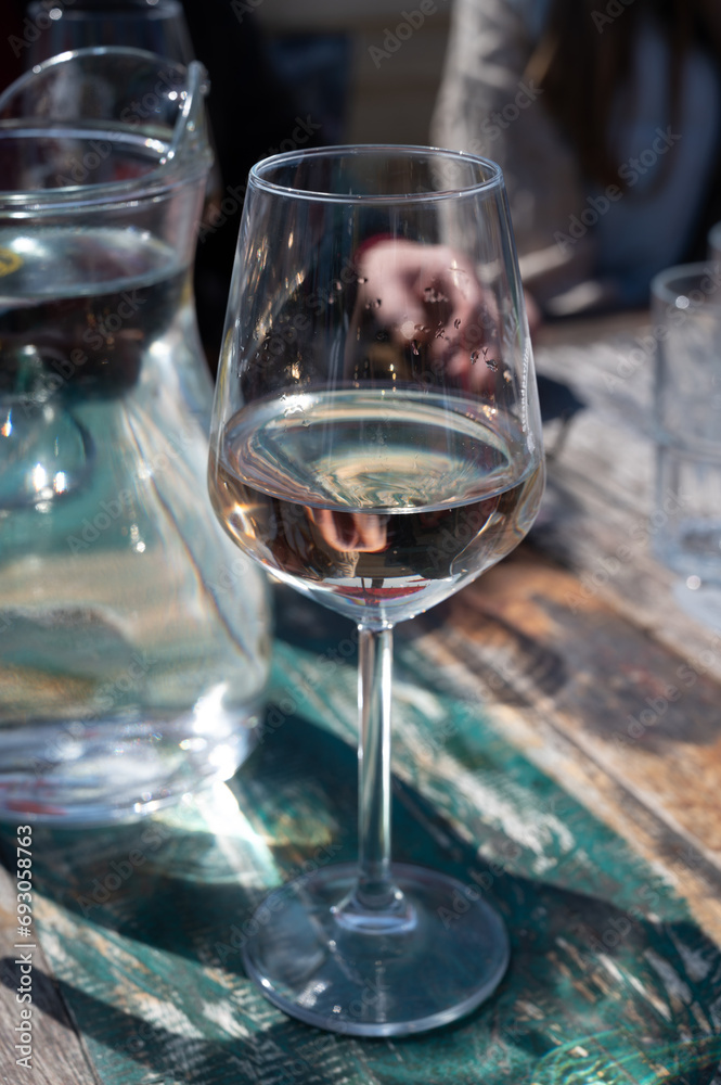 Drinking pinot grigio dry cold wine, served outdoor in beach cafe in North Holland, North sea sandy beach, the Netherlands