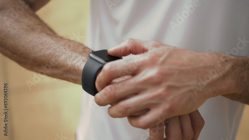 Hands touching smart watch close up. Athlete check performance data on display