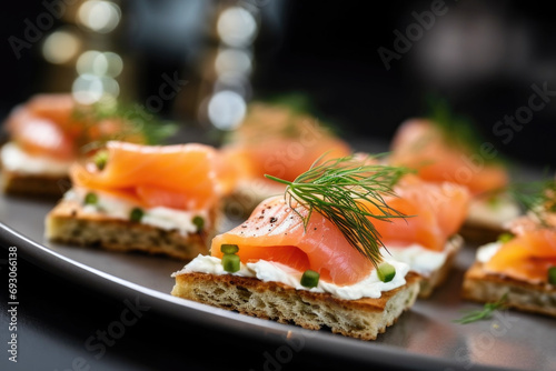 Delicious canapes with smoked salmon and dill on the plate close up photo