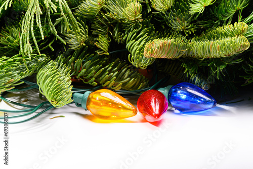 Christmas lights and pine wreath on a white background
