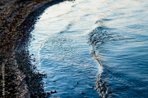 small waves near the lake shore closeup photo