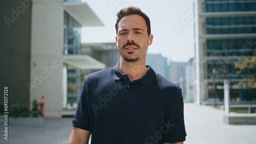 Confident businessman calling handsfree crossing to office closeup. Man talking