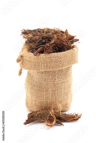 Close-up of Dry organic Jatamansi (Nardostachys jatamansi) roots, in a jute bag. Isolated over a white background. photo
