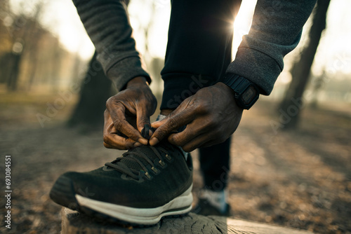 Man tying fitness shoes for outdoor run in park