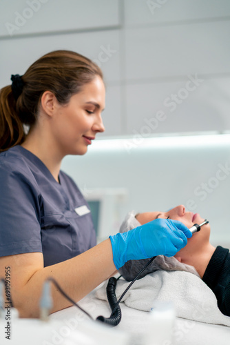 a beautician doctor massaging the skin of a client's face during a beauty and health cosmetic procedure