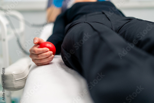 close-up of a woman's hand squeezing an anti-stress ball toy during a painful cosmetic procedure in a beauty salon