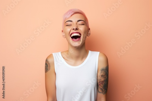 Portrait of happy cute girl with pink hair and tattooed hands, standing over pink background, wearing a white t-shirt. photo