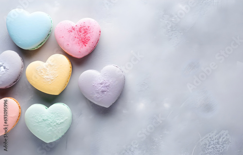colorful pastel heart shape macaron cookies on grey snowy background top view