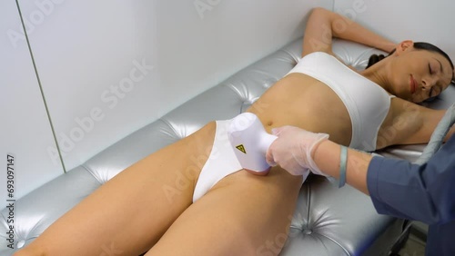 Woman having laser epilation, hair removal on bikini zone photo