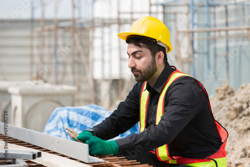 Foreman builder male at construction site. Male engineer inspecting work at construction site, wearing safety uniform, helmet