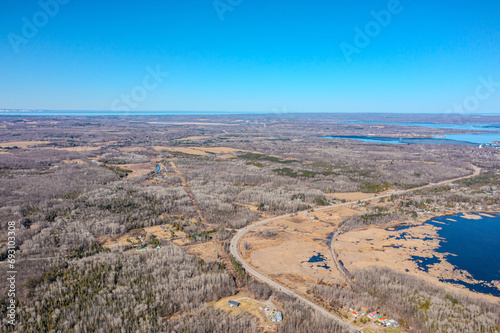 Expansive aerial views over Tay Township, Simcoe County, Ontario, capture the grandeur of the Canadian landscape. From the shimmering waters reflecting the sun's glare to the sprawling patches.