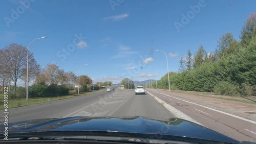 First person view, FPV, from dashcam of car driving in the city of Vitoria-Gasteiz in the Basque region, Northern Spain. Road trip video in POV, with bright sunny skies photo