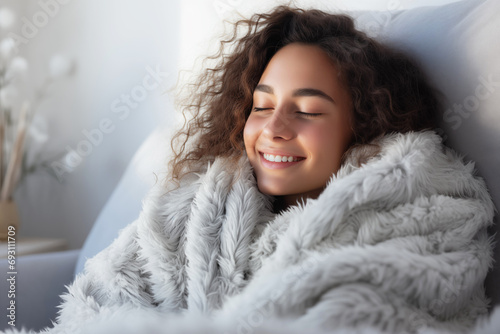 Happy Young Woman Feeling Cold at Home, covered in wool blanket