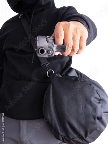 An unidentified male criminal wearing a black hoodie and covering his face, holding a handgun and carrying a large black money bag. On a white background with a cliping path.