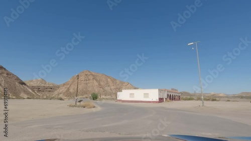 First person view, FPV, from dashcam of car driving towards abandoned diner in Tabernas desert, Almeria, Andalusia, Spain, Europe. Road trip video in POV in arid, dry climate photo