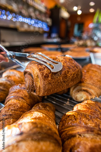Un pain au chocolat tenu dans des pinces dans une boulangerie en France