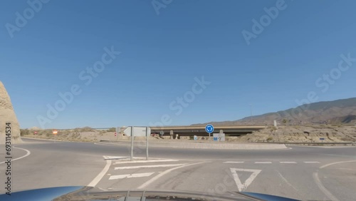 First person view, FPV, from dashcam of car driving on highway in Tabernas desert, Almeria, Andalusia, Spain, Europe. Road trip video in POV in arid, dry climate photo