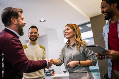 Multiethnic colleagues meeting their new associate in their modern office.