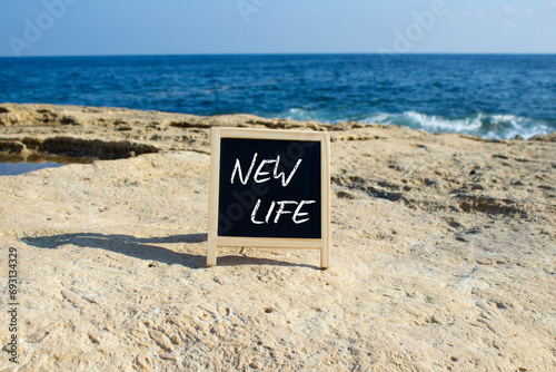 New life symbol. Concept words New life on black chalk background. Beautiful sea background. Business and New life concept. Copy space.