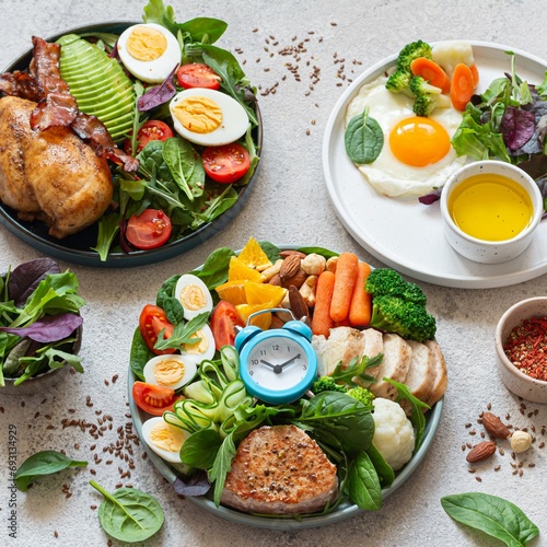 Vegetable plates with meat, fish and eggs. Complete diet for the day. Various breakfasts, lunches, snacks. Time to eat healthy foods. Eating by the hour. Health concept.