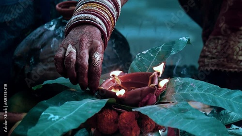 hindu puja a lady igniting dia with mehendi on his hand photo
