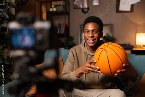 Obraz na plátně A basketball player-blogger in a cozy room, surrounded by books and basketball memorabilia, sharing his love for the game through his writing