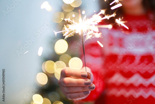 Young woman holding sparkler photo