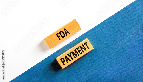 FDA Food and Drug Administration payment symbol. Concept words FDA payment on beautiful wooden blocks. Beautiful white and blue background. Business FDA payment concept. Copy space.