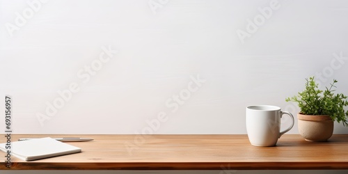 Front view of a workspace with a white desk table, copy space, supplies, and a coffee mug. photo