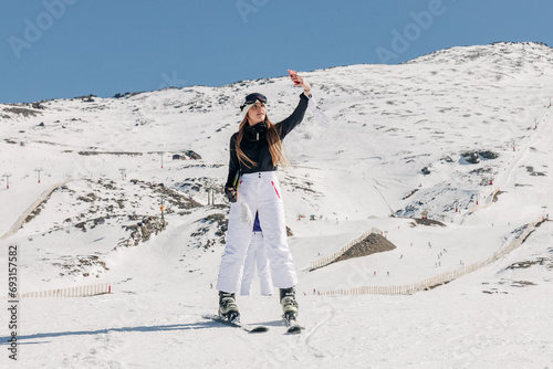 Female skier taking selfie on snowy hill