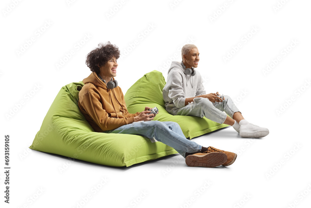 © Ljupco Smokovski - African american guy and caucasian guy sitting on bean bags and playing a video game with joysticks