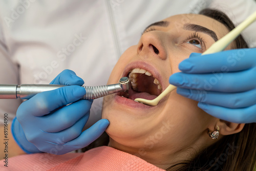 Dentist woman use dental drill while treating patient in the dental office