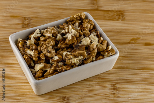 Peeled nuts in a porcelain bowl on a wooden cutting board