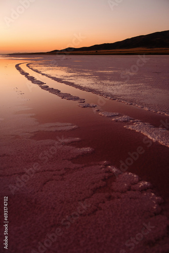 Summer sunset view with dried salt lake in Turkey. Pink salt covered everything around. Beauty of wild nature.