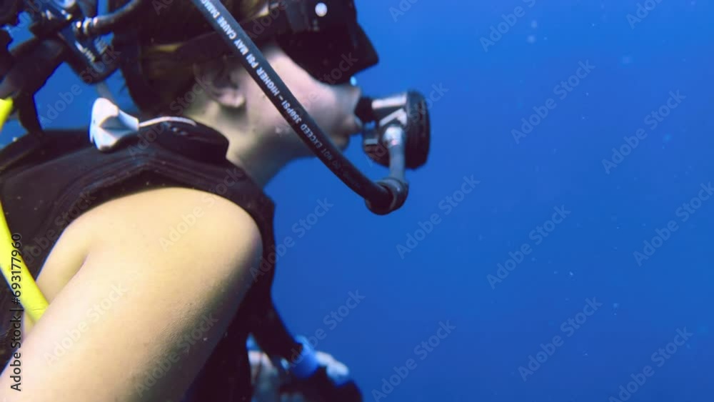 beautiful young woman diving underwater in Koh Tao Thailand looking around