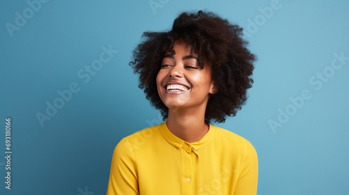 happy black woman with yellow shirt and a blue background © Samuel