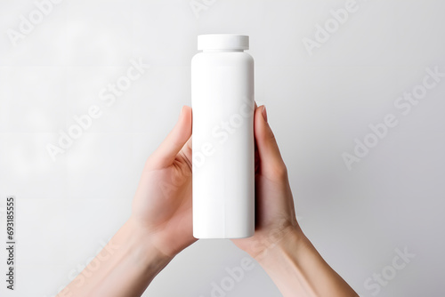 Female hands with White empty cosmetic liquid bottle of soap, lotion, shampoo or shower gel mock up isolated