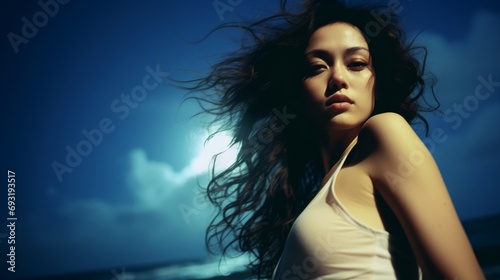 Beautiful woman in front of moonlight on the beach