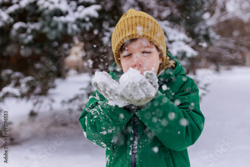 Boy playing with snow in the park