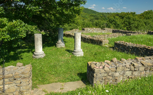 Ruins of a roman home with old columns near aroad in the old roman city Porolissum. Dacia province. Romania. photo