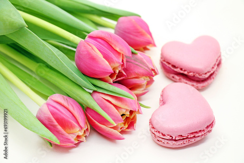 Bouquet of fresh pink tulips with heart-shaped macroons close-up. photo