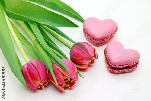 Bouquet of fresh pink tulips with heart-shaped macroons close-up. photo