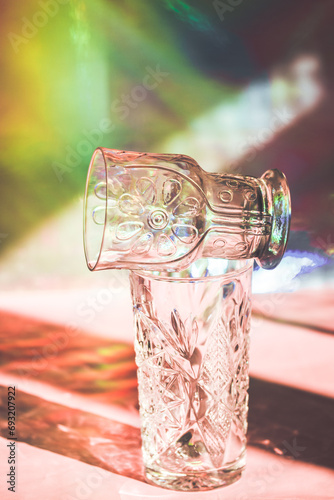 Photography Faceted glasses cast a shadow on a multicolored rainbow background