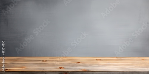 Gray background with empty wooden table top, used for displaying or arranging products. © Lasvu