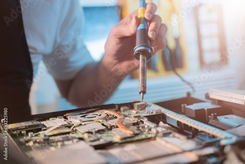 Close-up of a hand repairman specialist man repairs, and repairing electronics in a hardware repair shop