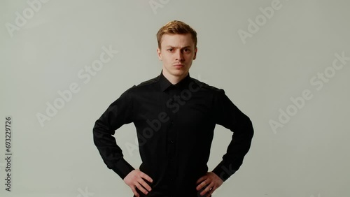 Serious bossy man in black shirt looking at you. Young guy with angry expression looks dissatisfied. Businessman look to camera with suspicious emotions. Worst results in company photo