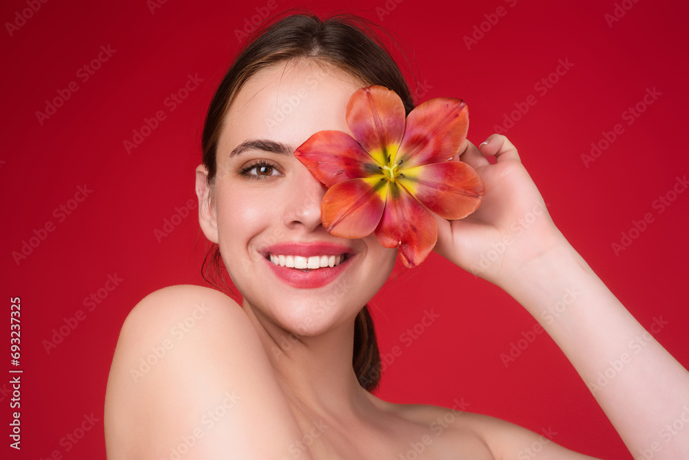 Beauty girl with tulip near face. Beautiful sensual woman hold tulips, studio portrait on red background. Beauty girl with tulip near face. Beautiful sensual woman hold tulips, studio portrait on red background.