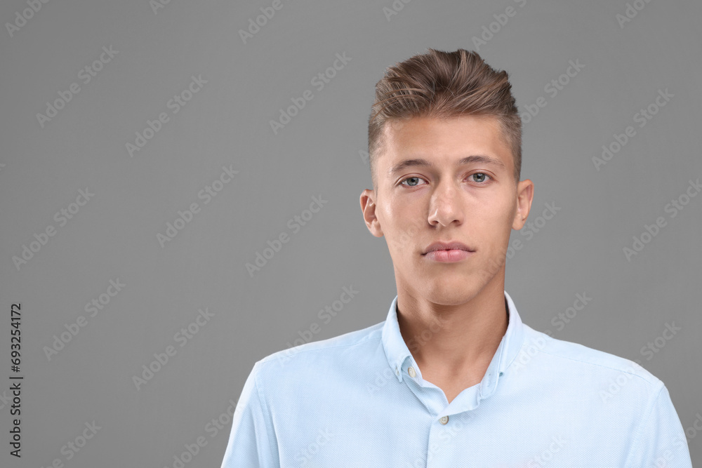 Portrait of handsome young man on grey background, space for text Portrait of handsome young man on grey background, space for text